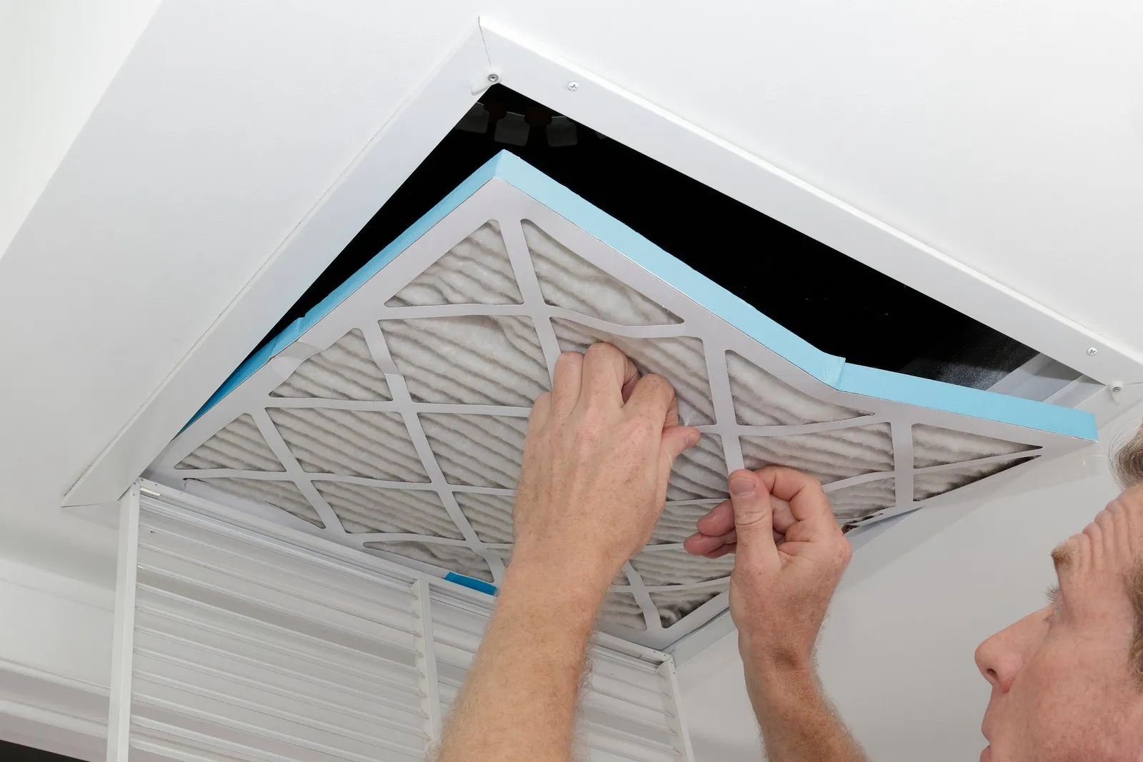 Technician cleaning an air duct vent in a Aurora home
